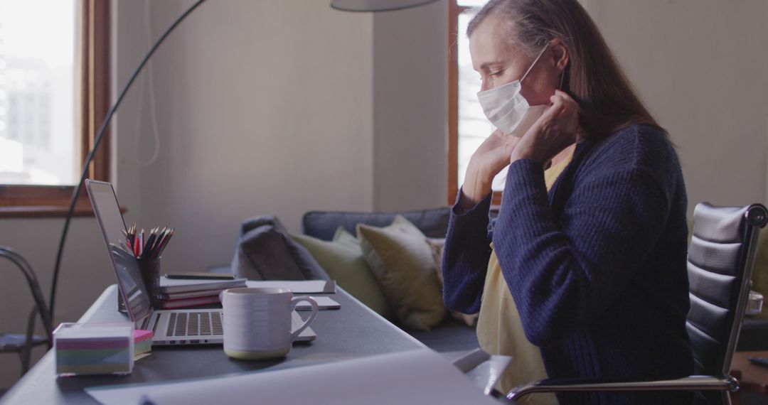 Remote Worker Adjusting Face Mask in Home Office - Free Images, Stock Photos and Pictures on Pikwizard.com