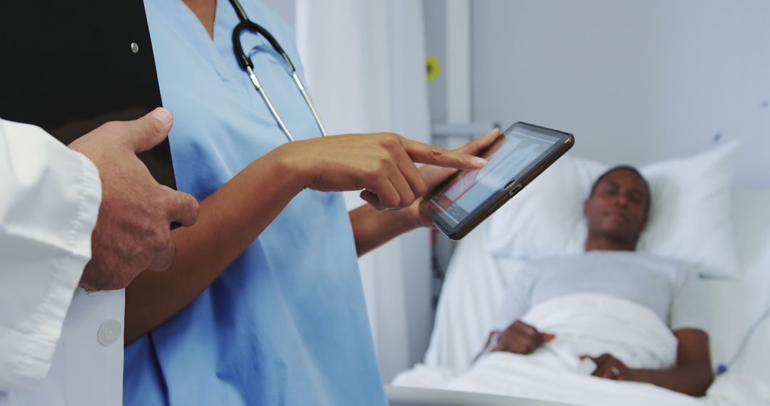 Medical Professionals Discussing Patient Using Digital Tablet in Hospital Room - Free Images, Stock Photos and Pictures on Pikwizard.com