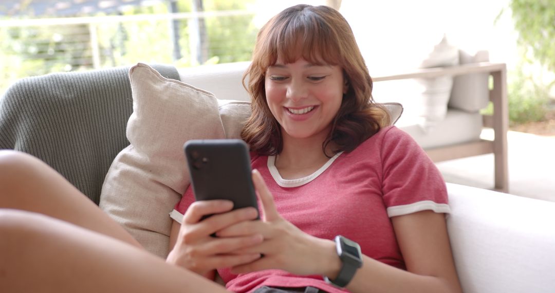Smiling Young Woman Enjoying Smartphone Relaxing at Home