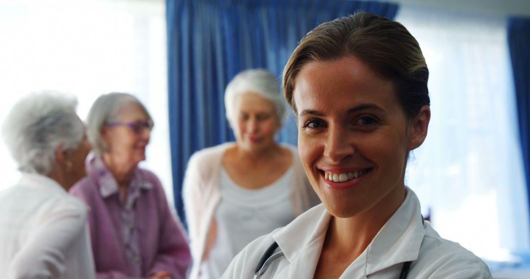 Smiling Female Doctor with Elderly Patients in Medical Setting - Free Images, Stock Photos and Pictures on Pikwizard.com