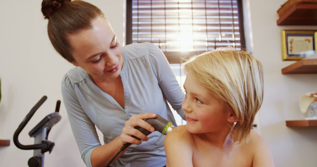 Female Therapist Using Ultrasound Therapy on Smiling Boy Indoors - Free Images, Stock Photos and Pictures on Pikwizard.com