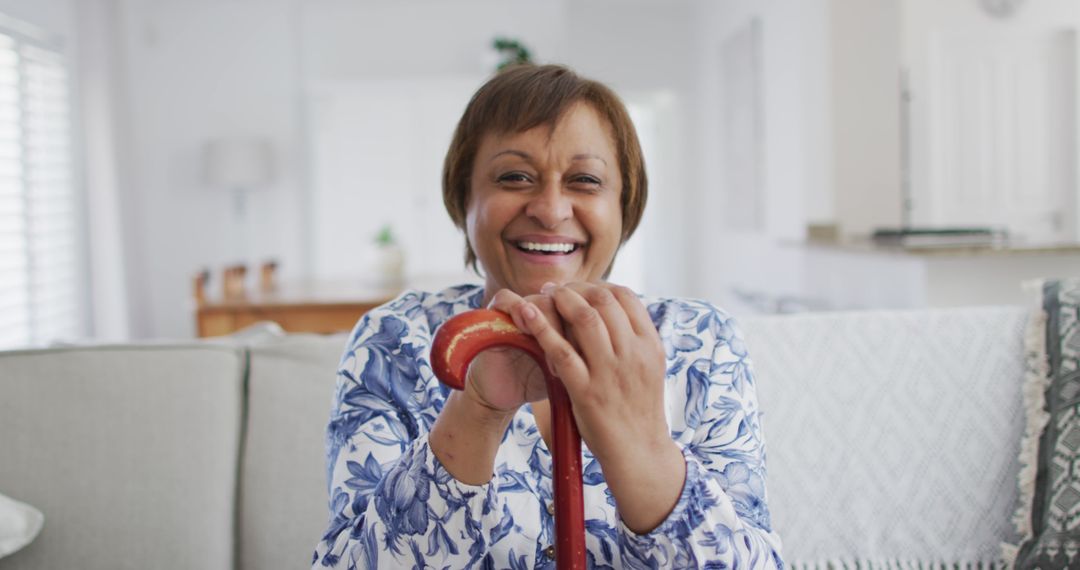 Senior Woman Smiling with Cane in Bright Living Room - Free Images, Stock Photos and Pictures on Pikwizard.com