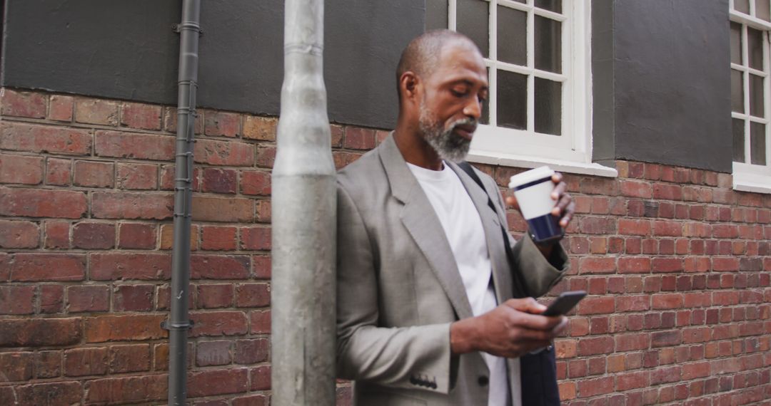 Businessman Taking Coffee Break While Checking Smartphone Outdoors - Free Images, Stock Photos and Pictures on Pikwizard.com