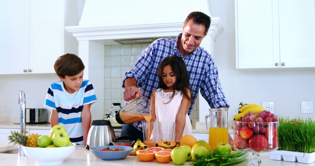 Father Pouring Juice for Children in Bright Modern Kitchen - Free Images, Stock Photos and Pictures on Pikwizard.com