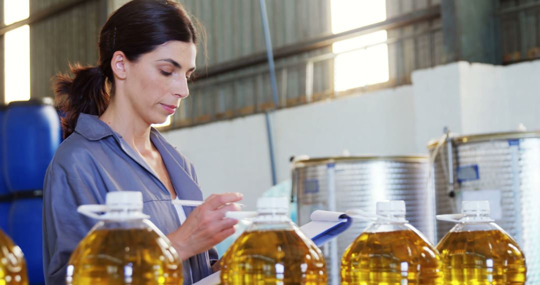 Female Quality Inspector Checking Cooking Oil Bottles in Factory - Free Images, Stock Photos and Pictures on Pikwizard.com