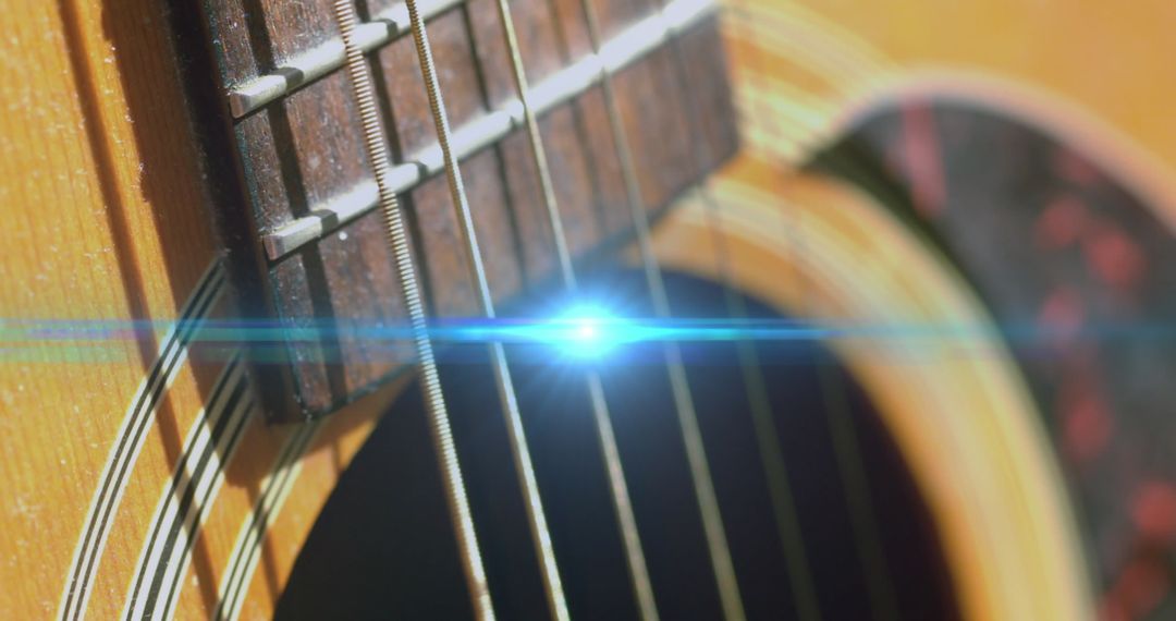 Close-Up of Vibrating Acoustic Guitar Strings with Light Flare