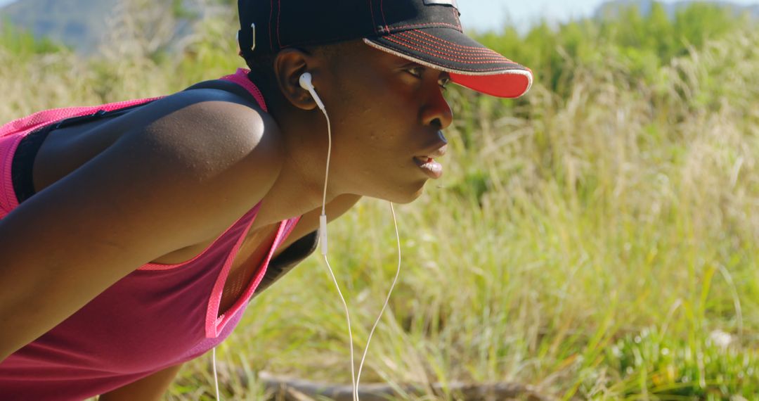 Focused Female Runner Warming Up Outdoors with Earphones - Free Images, Stock Photos and Pictures on Pikwizard.com