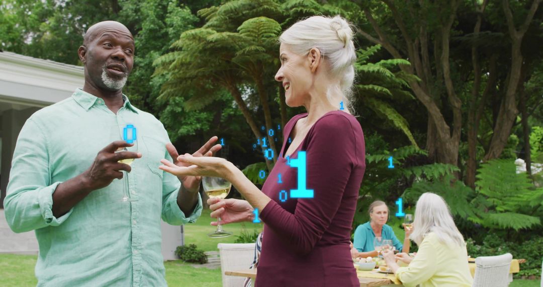Mature friends chatting and enjoying wine at outdoor garden party with binary data overlay