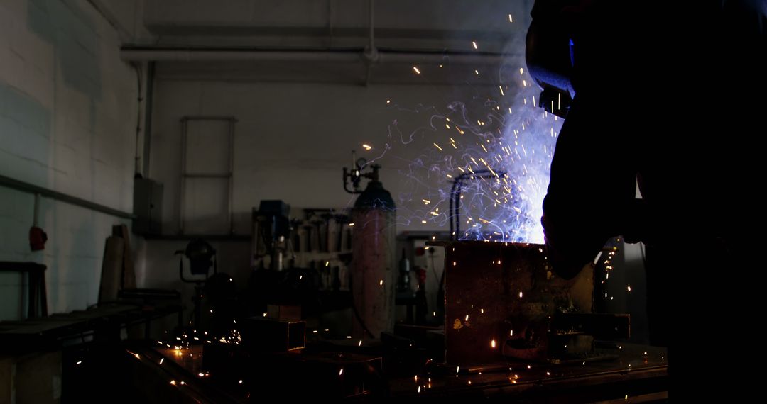 Welder Working with Bright Sparks in Industrial Workshop - Free Images, Stock Photos and Pictures on Pikwizard.com