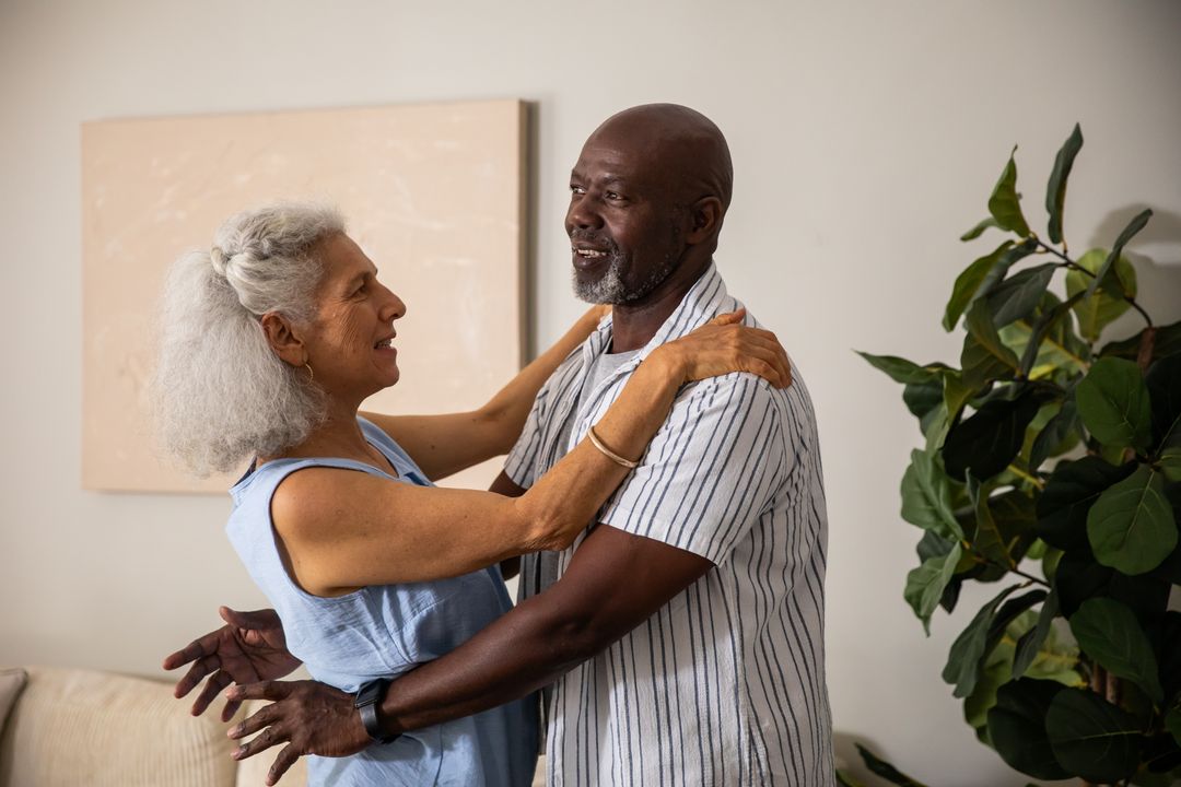 Senior Couple Embracing and Dancing at Home