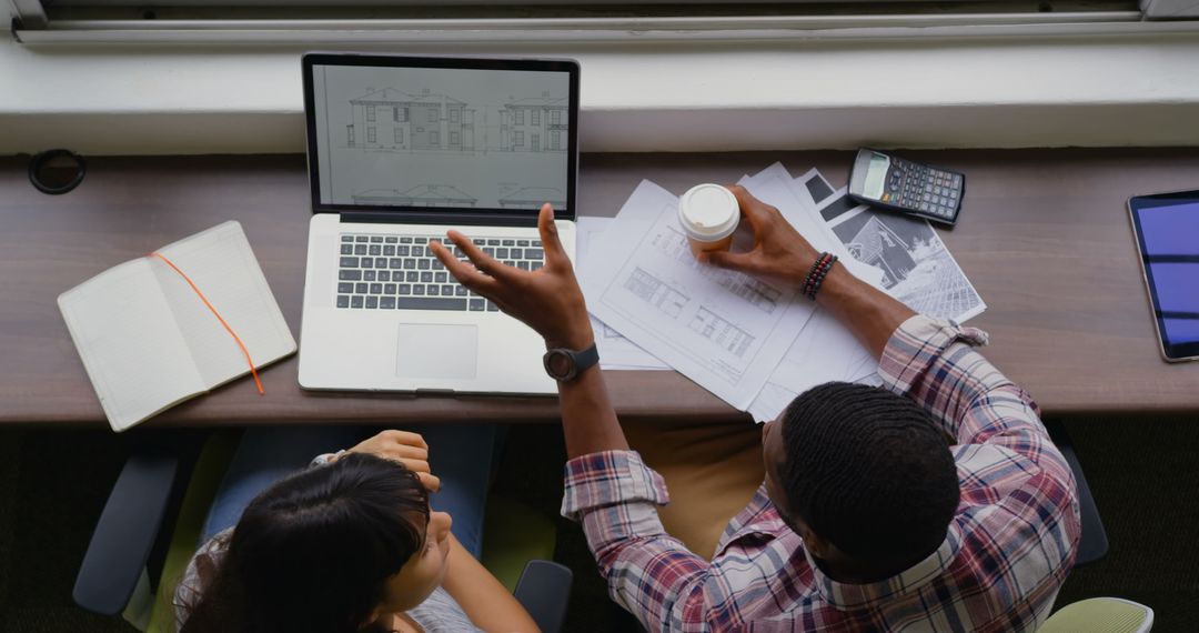 Architects Collaborating Over Architectural Plans in Office
