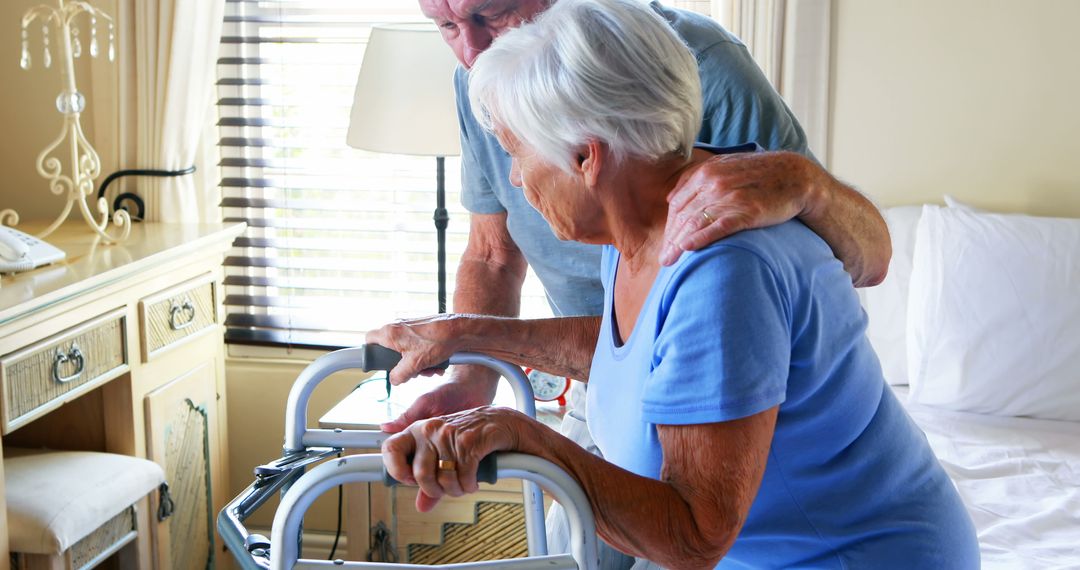 Senior man helping elderly woman with walker in bedroom - Free Images, Stock Photos and Pictures on Pikwizard.com