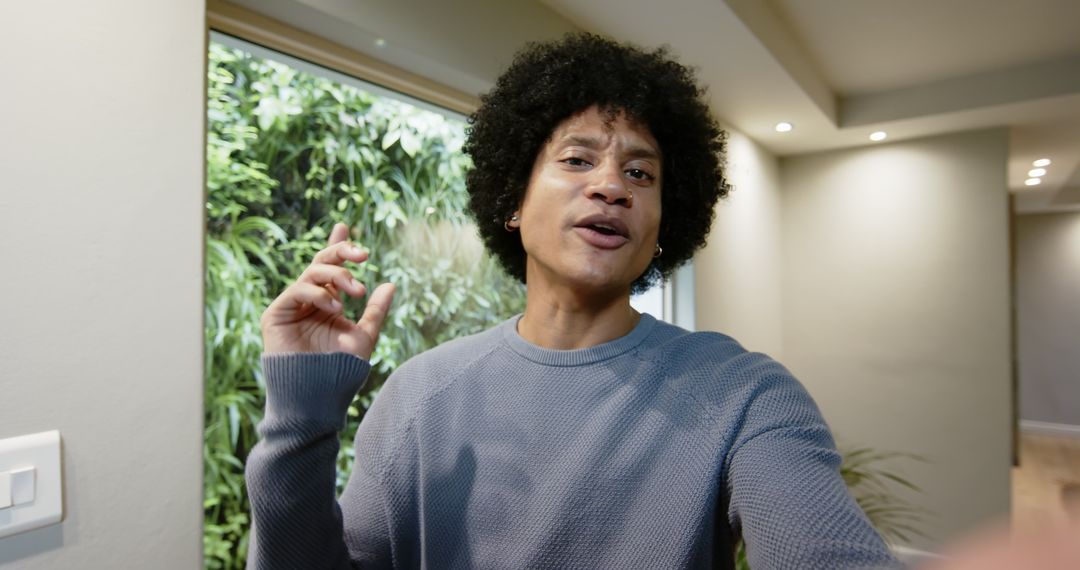 Man in Modern Hallway Conversing with Camera Enthusiastically