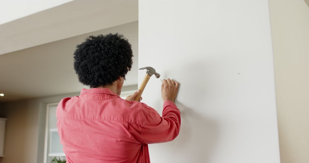 Man Skillfully Using Hammer for Home Improvement in Modern Kitchen