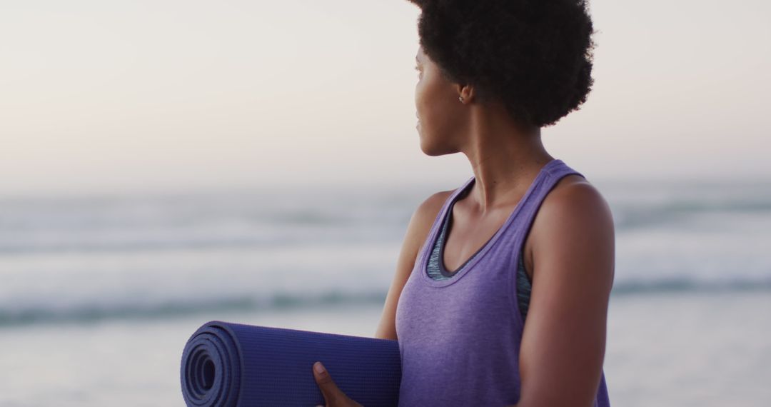 Portrait of happy african american woman with yoga mat on sunny beach - Free Images, Stock Photos and Pictures on Pikwizard.com