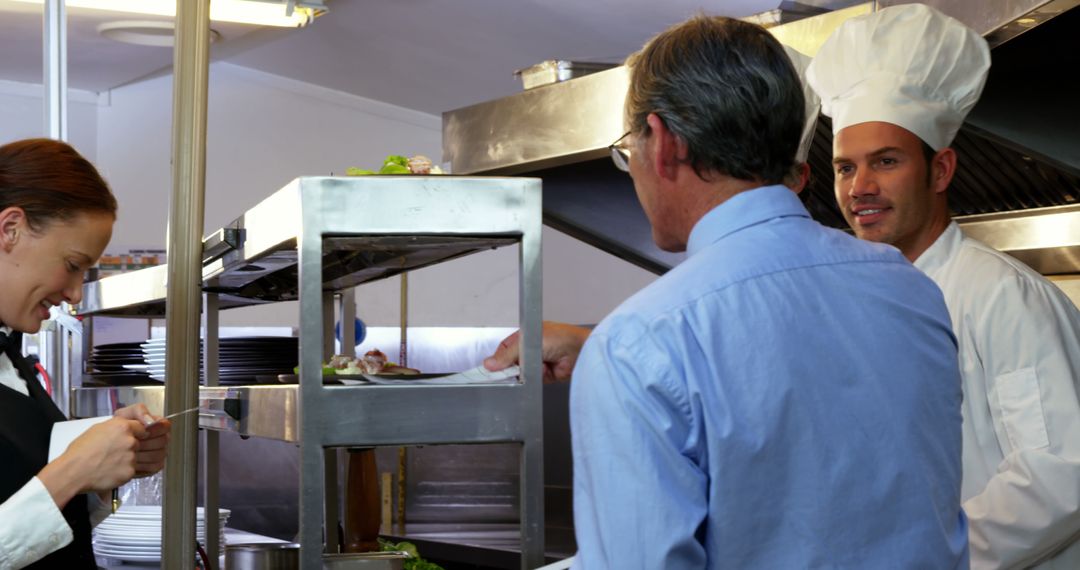 Waiter and Chef Communicating in Professional Kitchen
