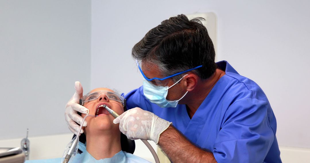 Dentist Treating Patient in Clinic with Professional Equipment - Free Images, Stock Photos and Pictures on Pikwizard.com