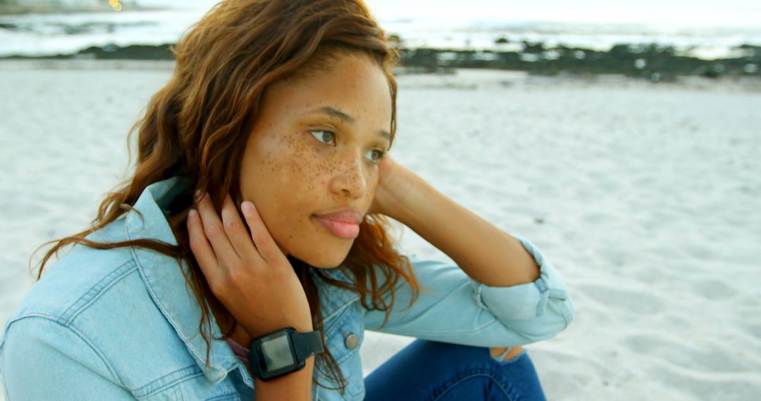 Reflective Young Woman Sitting on Sandy Beach During Sunset - Free Images, Stock Photos and Pictures on Pikwizard.com