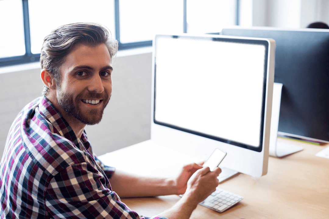 Smiling Professional Holding Phone by Blank Transparent Monitor