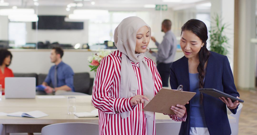 Diverse Business Professionals Discussing Work in Modern Office