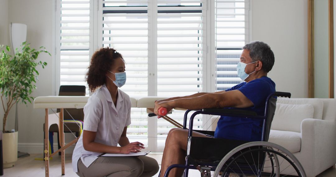 Caregiver Consulting Patient in Wheelchair with Medical Mask at Home - Free Images, Stock Photos and Pictures on Pikwizard.com