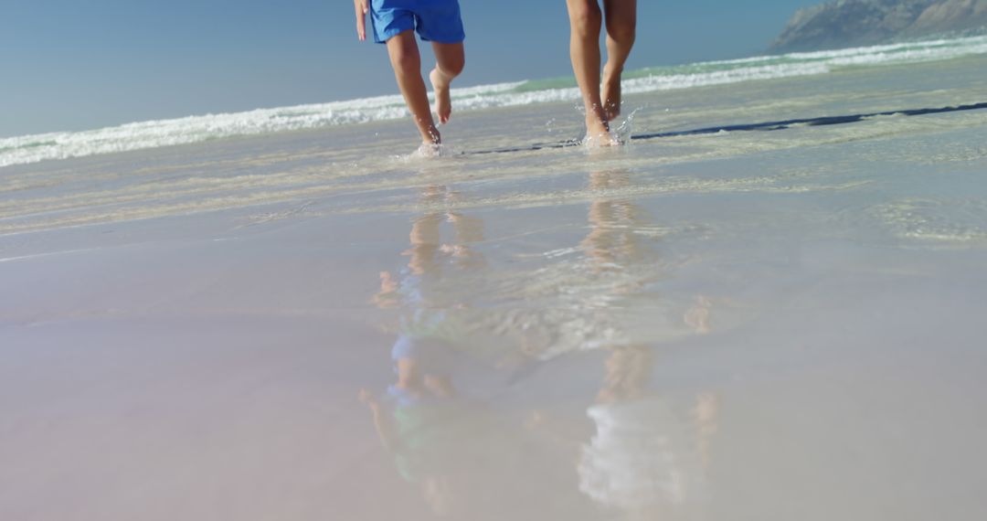 People Running on Beach with Clear Ocean Water - Free Images, Stock Photos and Pictures on Pikwizard.com