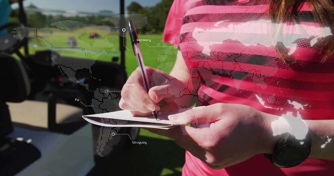 Writing notes on notepad at golf course with dotted world map overlay, outdoor lifestyle