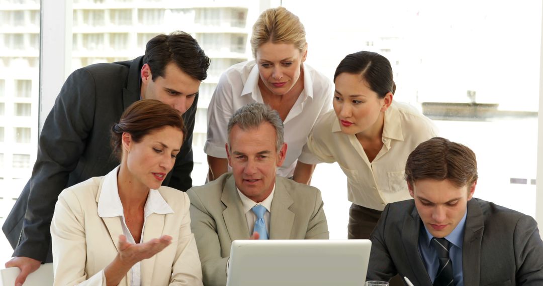Business Team Collaborating around Laptop in Office Setting