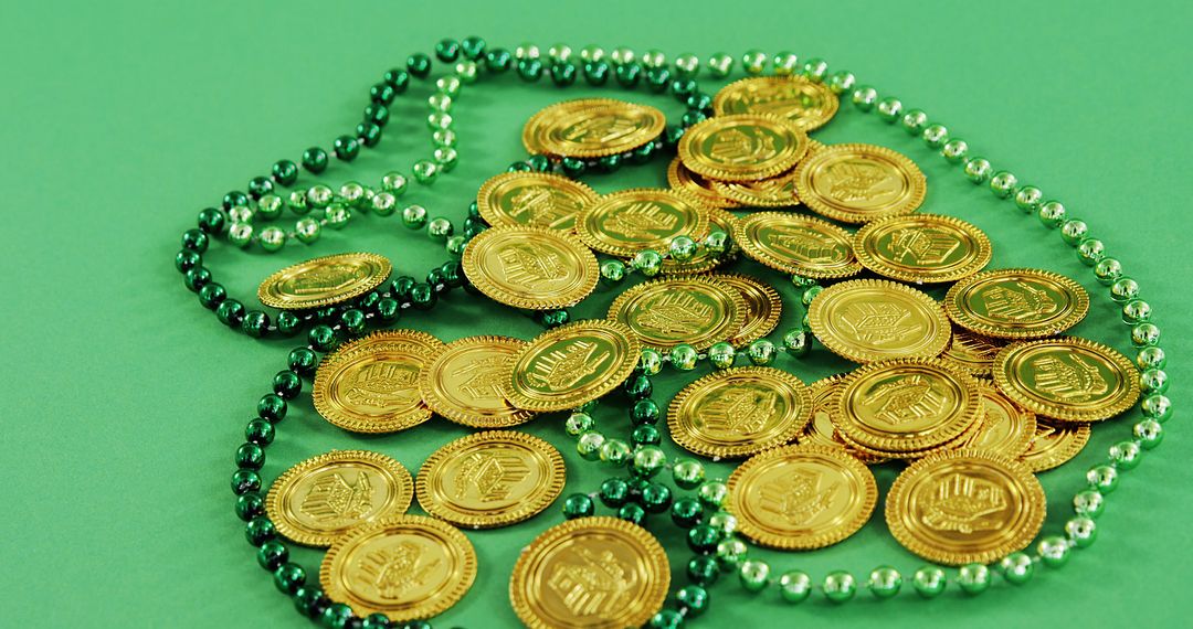 Gold coins and green beads on a green surface suggest a festive celebration of wealth or luck. - Free Images, Stock Photos and Pictures on Pikwizard.com