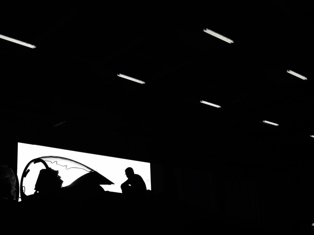 Silhouette of Aircraft Technician in Hangar Under Dramatic Lighting - Free Images, Stock Photos and Pictures on Pikwizard.com