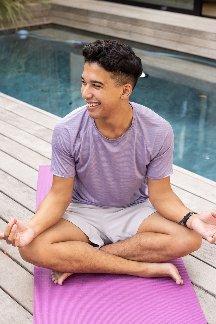 Man Practicing Yoga Outdoors by Pool on Sunny Day
