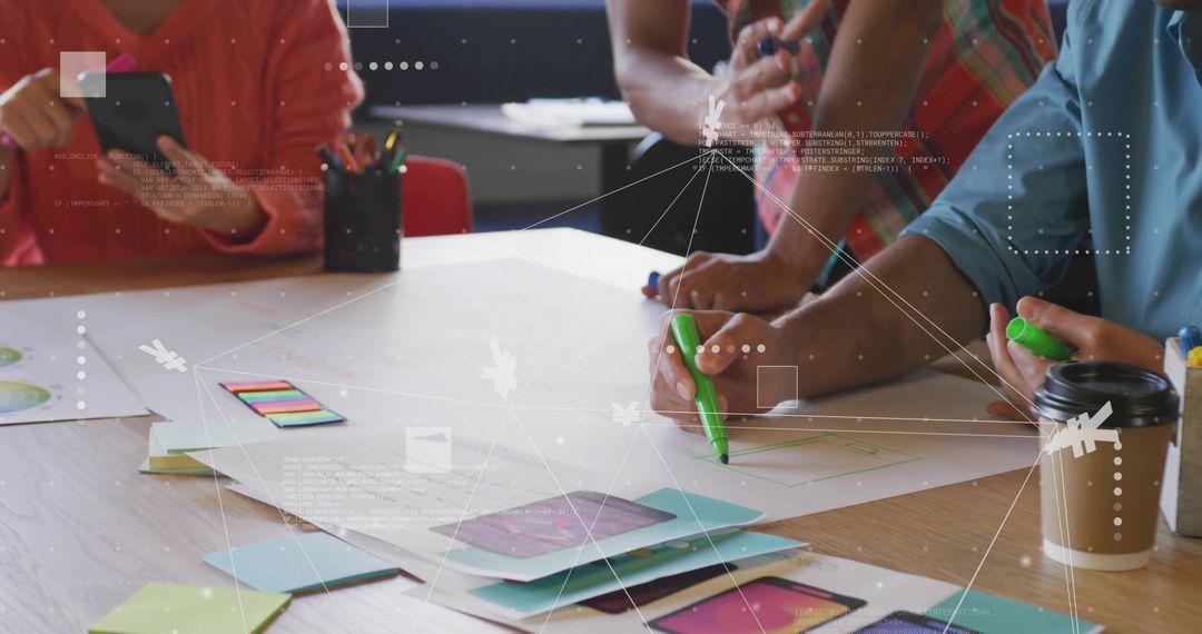 Design team sketching mobile app prototypes with markers, sticky notes and smartphone