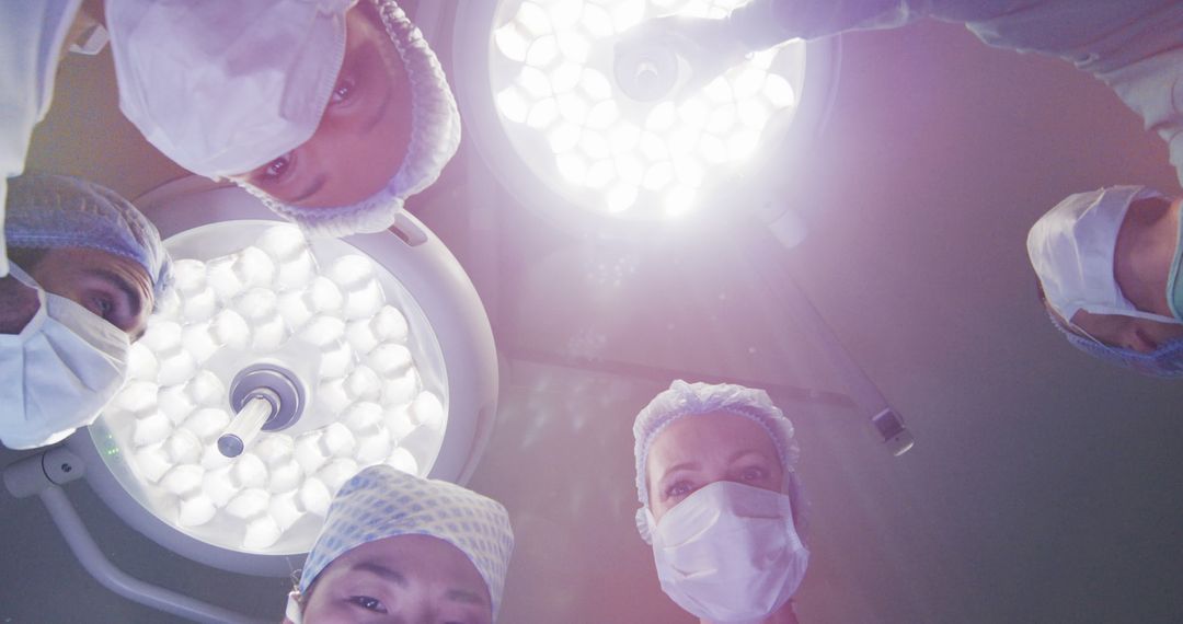 Surgeons Performing Operation Under Bright Lights in Operating Room - Free Images, Stock Photos and Pictures on Pikwizard.com