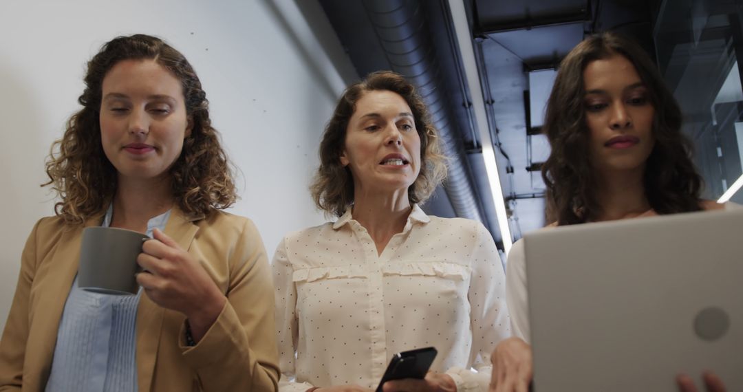 Three Businesswomen Collaborating in Modern Office Hallway - Free Images, Stock Photos and Pictures on Pikwizard.com