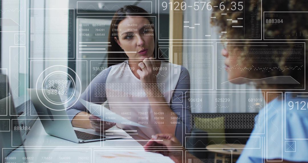 Women Collaborating at Office Desk Amidst Data Visualization Overlays