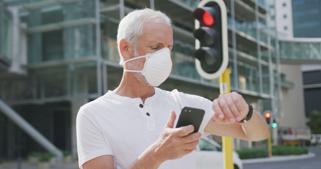 Senior Man Wearing Face Mask Using Smartphone and Checking Time Outdoors - Free Images, Stock Photos and Pictures on Pikwizard.com