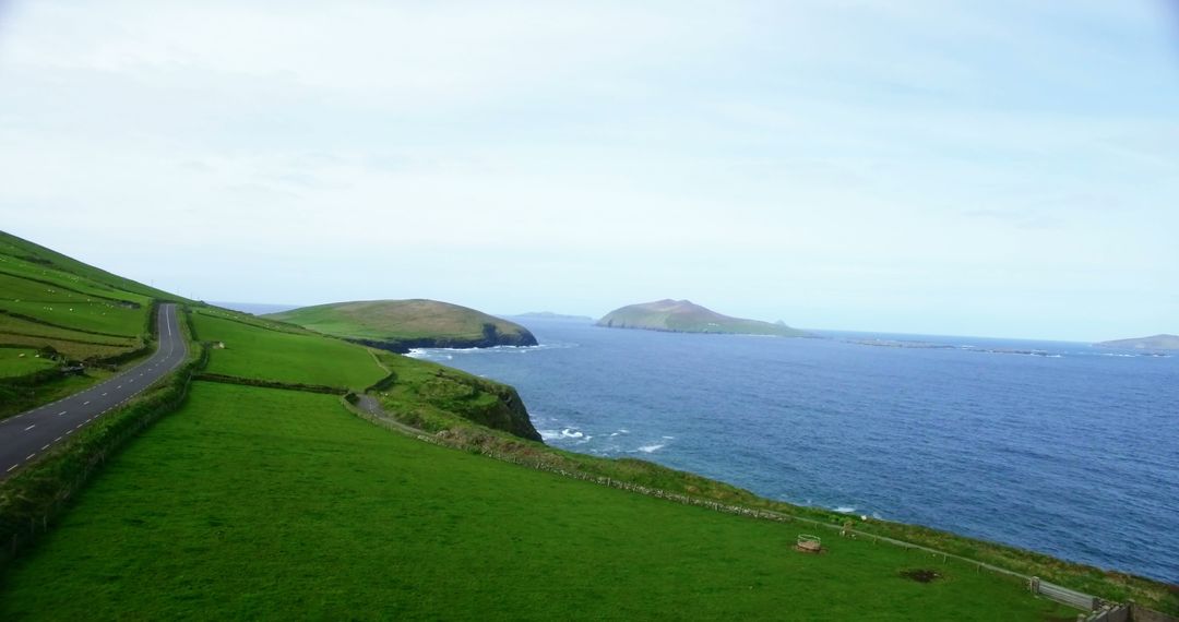 A scenic coastal road offers a serene travel backdrop with rolling hills and distant islands. - Free Images, Stock Photos and Pictures on Pikwizard.com