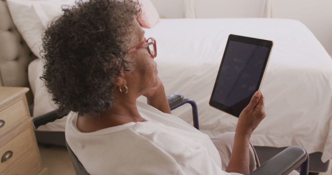 Senior african american woman sitting in wheelchair and using tablet with copy space on screen - Free Images, Stock Photos and Pictures on Pikwizard.com