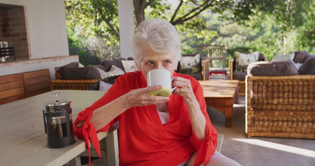 Mature Woman Drinking Coffee on Patio with French Press - Free Images, Stock Photos and Pictures on Pikwizard.com