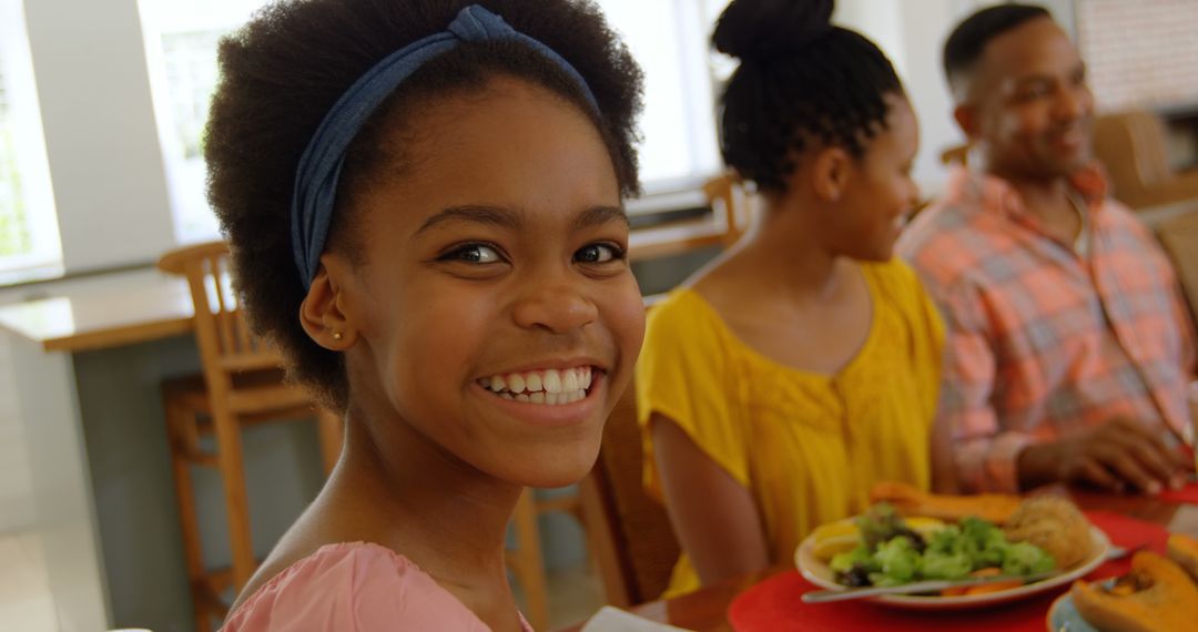 Cheerful African American Girl Having Lunch with Family - Free Images, Stock Photos and Pictures on Pikwizard.com