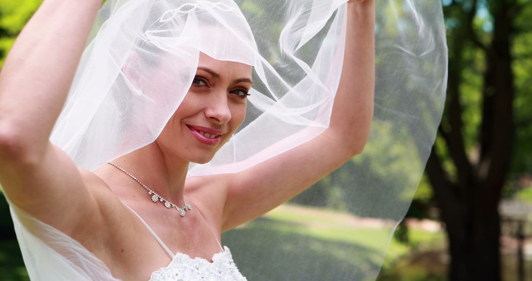 Smiling Bride Lifting Veil in Sunny Garden Wedding - Free Images, Stock Photos and Pictures on Pikwizard.com