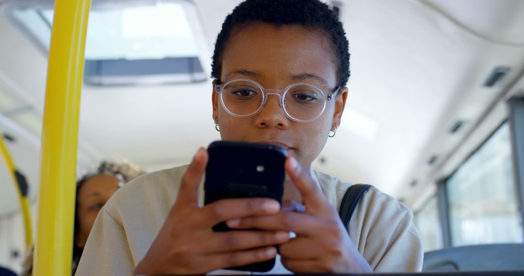 Young Woman Wearing Glasses Using Smartphone on Public Bus - Free Images, Stock Photos and Pictures on Pikwizard.com