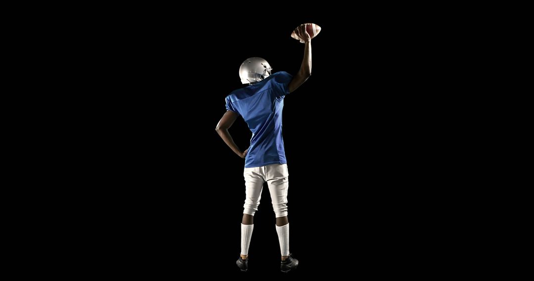 African American Football Player Holding Ball Triumphantly on Black Background - Free Images, Stock Photos and Pictures on Pikwizard.com