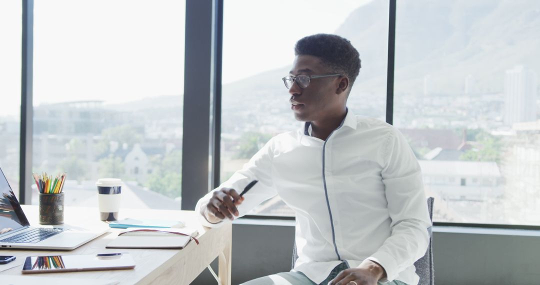 Focused Young African American Man Working in Modern Office with Scenic View - Free Images, Stock Photos and Pictures on Pikwizard.com