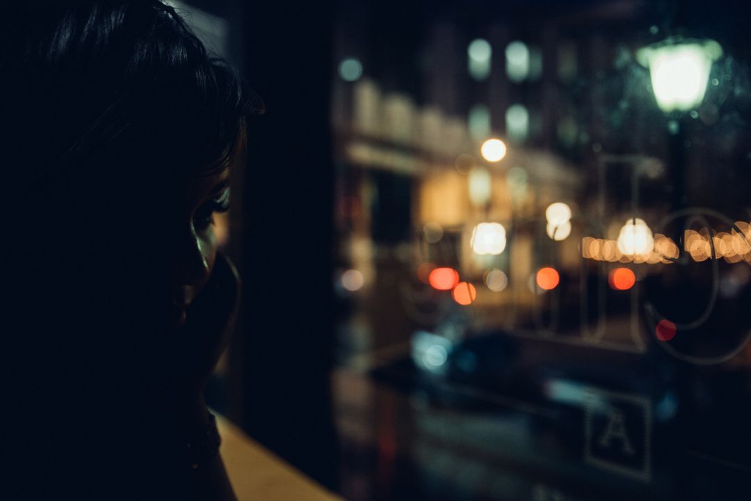 Silhouette of Person at Urban Window Overlooking City Night Lights - Free Images, Stock Photos and Pictures on Pikwizard.com