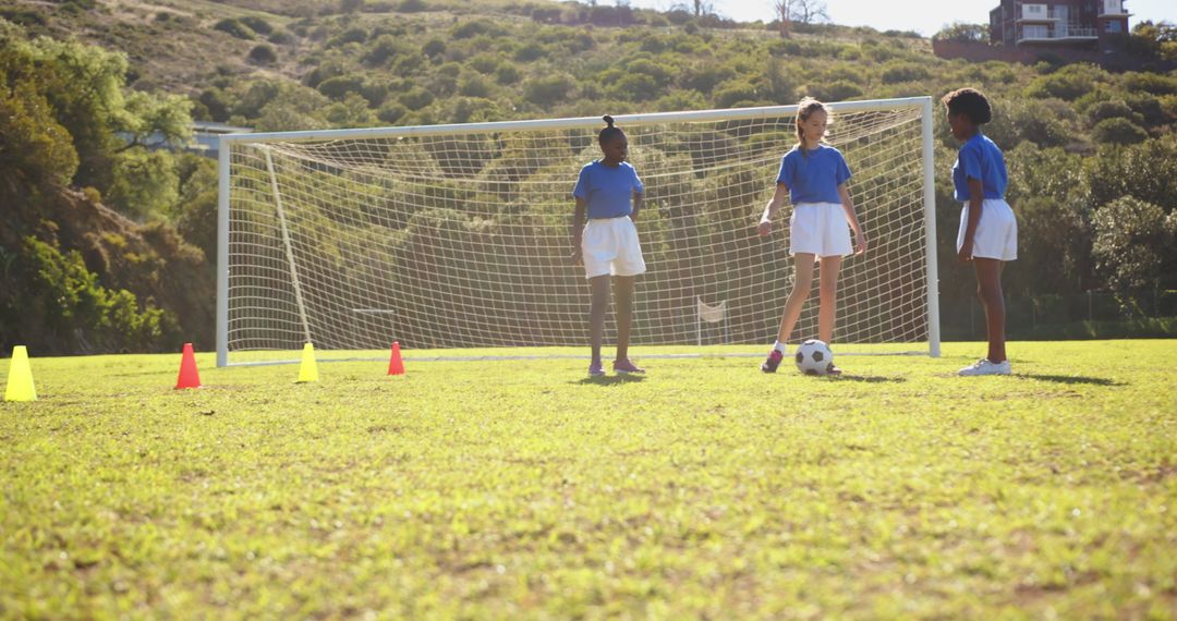 Girls Practicing Soccer Strategies with Ball and Cones