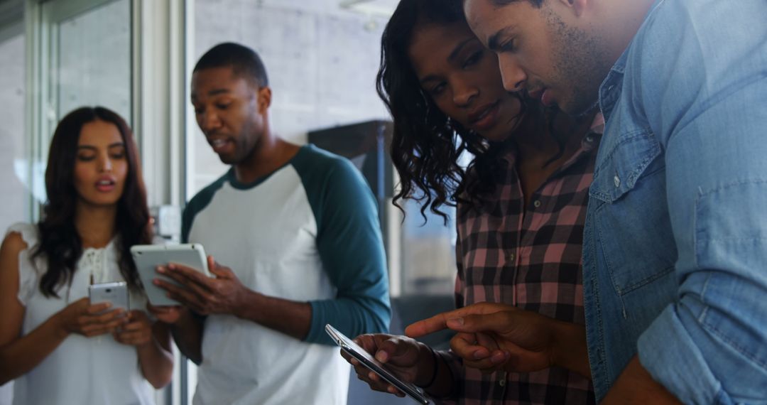 Diverse Team Collaborating on Digital Devices in Office Environment