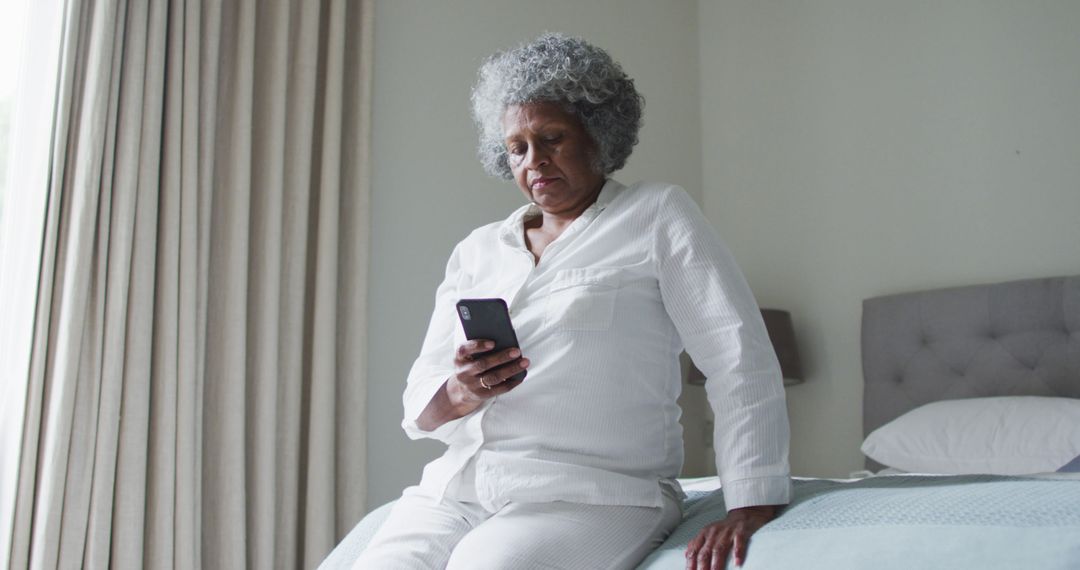 Senior African American Woman Texting on Mobile Phone at Home - Free Images, Stock Photos and Pictures on Pikwizard.com