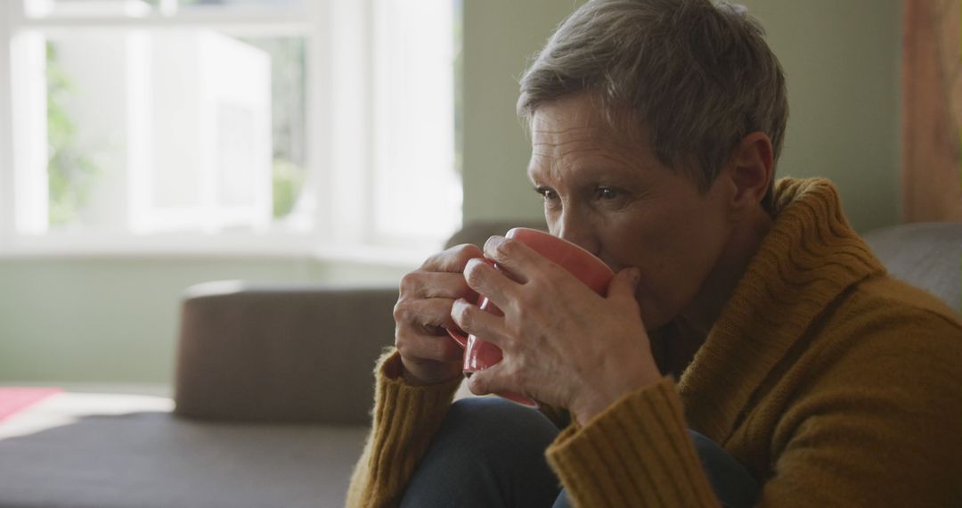 Older woman relaxing indoors drinking coffee - Free Images, Stock Photos and Pictures on Pikwizard.com