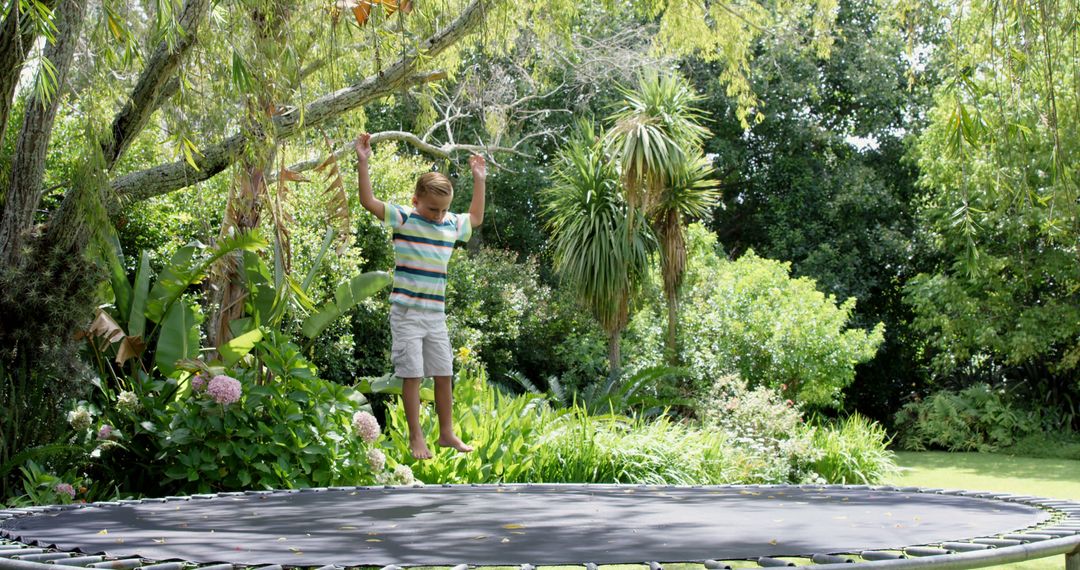 Happy Child Bouncing on Outdoor Trampoline in Lush Green Garden - Free Images, Stock Photos and Pictures on Pikwizard.com